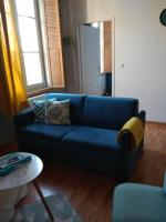a blue couch in a living room with a table at Appartement calme proche de la Loire in Saumur