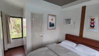 a bedroom with a bed and a window in it at Bakawan Hideaway Resort and Restaurant in Tomas Oppus