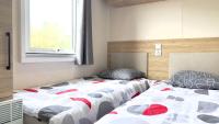 Łóżko lub łóżka w pokoju w obiekcie L'incontournable Tout Confort Camping Siblu