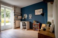 a room with a blue wall with a desk and a window at Maison 5 chambres #8pers #Stationnement gratuit in Cognac