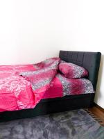 - un lit avec des couvertures rouges et roses dans l&#39;établissement Apartman Sanjar Vidikovac, à Kneževac