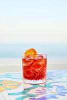 a drink on a table with an orange on top at Hotel Conca d'Oro in Positano