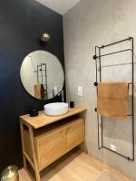 a bathroom with a sink and a mirror at Au ptit Manoir in Montbert