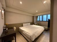 a bedroom with a white bed and a desk and a desk at Link World Hotel in Taipei