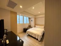 a bedroom with a bed and a desk and a window at Link World Hotel in Taipei