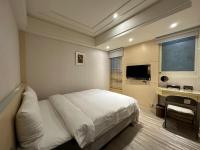 a bedroom with a white bed and a television at Link World Hotel in Taipei