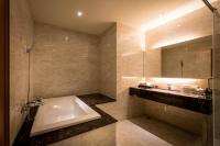 a bathroom with a bath tub and a sink at Chateau-Rich Hotel in Tainan