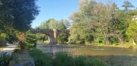 a bridge over a river with trees and water at Le lorrain in Campagne-sur-Aude