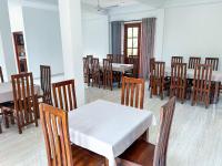 comedor con mesa blanca y sillas de madera en Hotel Grand Resto, en Katugastota