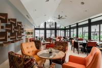 a restaurant with orange chairs and tables and windows at Domitys Bangsar Kuala Lumpur in Kuala Lumpur