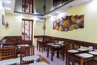 een restaurant met tafels en stoelen en schilderijen aan de muren bij Shakh Sultan in Tasjkent