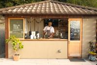 Un hombre está de pie frente a un mostrador en un bar. en てんとうみ 渋川海岸グランピング Tentoumi Shibukawa Beach Glamping, en Tamano