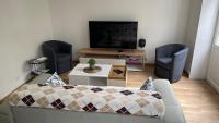 a living room with a couch and a flat screen tv at Au Beau Duplex de la Basilique in Boulogne-sur-Mer