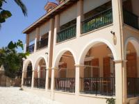 a building with arches and balconies on it at Loukas Inn Family Resort in Keri