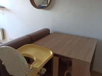 a wooden table with a yellow chair next to a couch at Appartement Villers-sur-Mer, 2 pièces, 4 personnes - FR-1-712-41 in Villers-sur-Mer