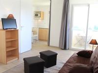 a living room with a couch and a kitchen with a window at Appartement La Rochelle, 2 pièces, 4 personnes - FR-1-246-648 in La Rochelle