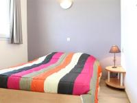 a bed with a colorful striped blanket in a room at Appartement La Rochelle, 2 pièces, 4 personnes - FR-1-246-648 in La Rochelle