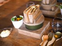 Una tabla de cortar de madera con una barra de pan sobre una mesa en 古民家オーベルジュmocca, en Kokuryō