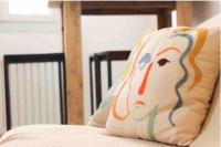 a pillow with a face on it sitting on a bed at Cosy studio situé en plein cœur du vieil antibes. in Antibes