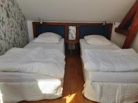 two beds in a small room with white sheets at Le Clos du Buisson in Saint-Julien-de-la-Liègue