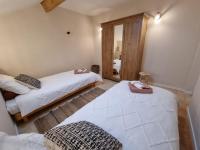 a bedroom with two beds and a mirror at La Ferme de Philomène - Gîte en Périgord Noir in Sainte-Foy-de-Belvès