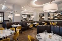 JW Marriott Tampa Water Street في تامبا: مطعم به طاولات مستديره وكراسي صفراء