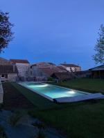 a large swimming pool in the yard of a house at Le Clos des Grands Frênes in Pons