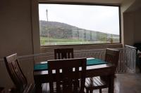 jadalnia ze stołem i krzesłami oraz dużym oknem w obiekcie Bhalil Farm House w mieście Sefrou