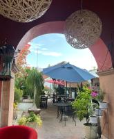 un patio con ombrellone, tavoli e piante in vaso di Suite Los Angeles a Tecozautla