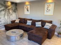 a living room with a brown couch and a table at Nouveau !! Bel appartement à Fécamp tout près de la plage, gare et voie verte in Fécamp