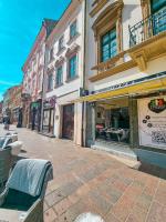 a street with buildings and a bench on a sidewalk at Hlavna Apartment Kosice in Košice