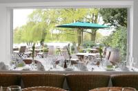 una mesa con vasos y una sombrilla azul en Landhaus am See, en Garbsen