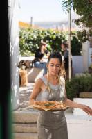 una mujer sosteniendo una bandeja de pizza en LEGASEA - Cascais Guesthouse, en Cascais