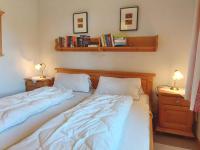 two beds in a bedroom with two lamps and books at Holiday home in Bad Mitterndorf - Steiermark 41114 in Bad Mitterndorf