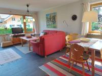 a living room with a red couch and a table at Holiday home in Bad Mitterndorf - Steiermark 41114 in Bad Mitterndorf