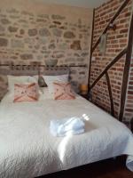 a bedroom with a white bed with pink pillows at Chambre Rdc in Saint-Aubin-le-Monial