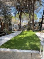 a green lawn with trees and benches in a yard at Camping Oasis village in Puget-sur-Argens