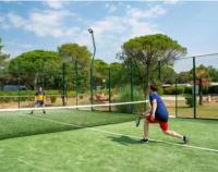 two people playing tennis on a tennis court at Camping Oasis village in Puget-sur-Argens