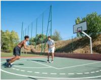 two men playing a game of basketball on a court at Camping Oasis village in Puget-sur-Argens