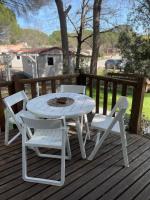 a white table and two chairs on a deck at Camping Oasis village in Puget-sur-Argens