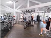 a man sitting on a chair in a gym at Camping Oasis village in Puget-sur-Argens