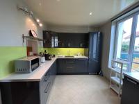 a kitchen with black and green cabinets and a microwave at Maison Climatisée 04 chambres Paris Disney CDG in Gagny