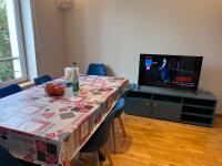 a table with a table cloth on it with a tv at Maison Climatisée 04 chambres Paris Disney CDG in Gagny