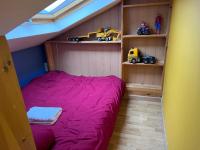 a bedroom with a bed and shelves with toy trucks at Maison Climatisée 04 chambres Paris Disney CDG in Gagny
