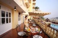 a man standing on the balcony of a restaurant at Victoria Chau Doc Hotel in Chau Doc