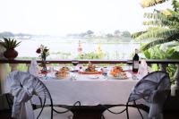 a table with food and wine and a view of a river at Victoria Chau Doc Hotel in Chau Doc