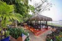 a pavilion with a straw roof in a garden at Victoria Chau Doc Hotel in Chau Doc
