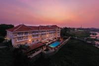 a building with a swimming pool in front of a sunset at Victoria Chau Doc Hotel in Chau Doc