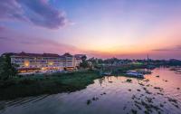 a view of a river at sunset with a building at Victoria Chau Doc Hotel in Chau Doc