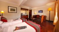 a hotel room with two beds and a desk at Victoria Chau Doc Hotel in Chau Doc